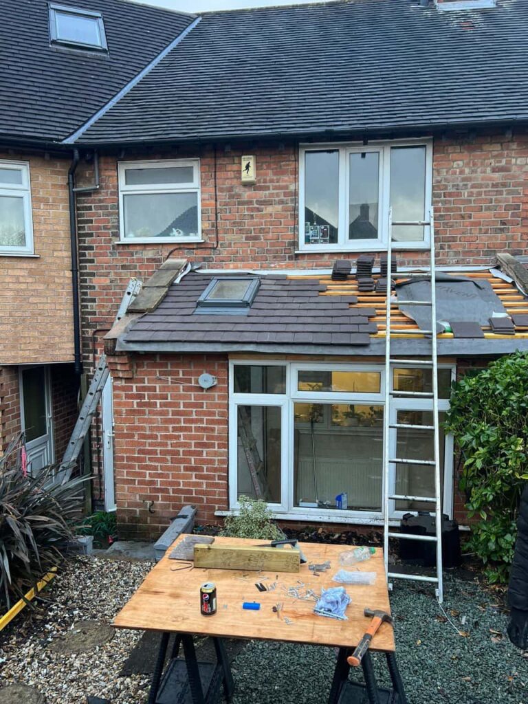 This is a photo of a roof extension that is having new roof tiles installed. This is a photo taken from the roof ridge looking down a tiled pitched roof on to a flat roof. Works carried out by Gamston Roofing Repairs